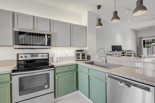 6936 Stoney Creek Cir, Lake Worth, FL 33467 - kitchen featuring stainless steel appliances, a sink, light countertops, hanging light fixtures, and open floor plan