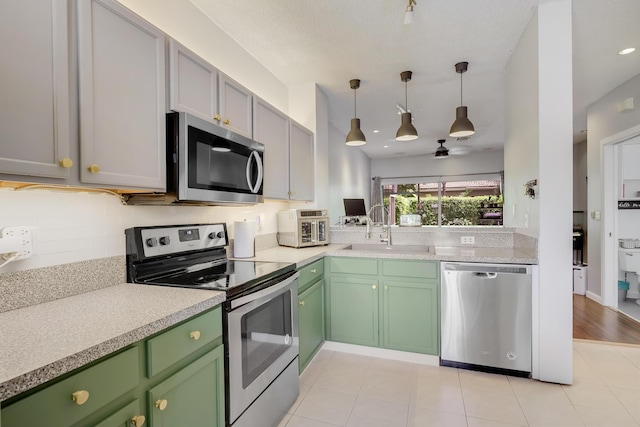 6936 Stoney Creek Cir, Lake Worth, FL 33467 - kitchen featuring appliances with stainless steel finishes, a sink, light countertops, and green cabinetry