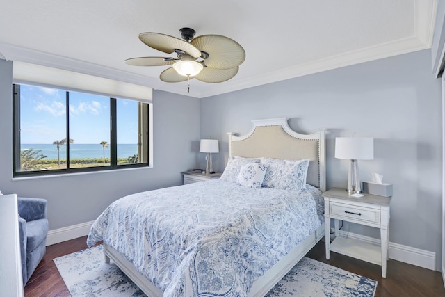 bedroom with baseboards, wood finished floors, crown molding, and ceiling fan
