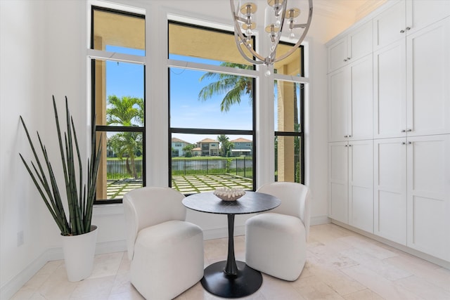dining space featuring a chandelier, a water view, and baseboards