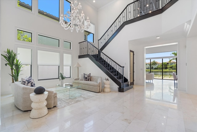 living room featuring a towering ceiling, stairway, a chandelier, and marble finish floors