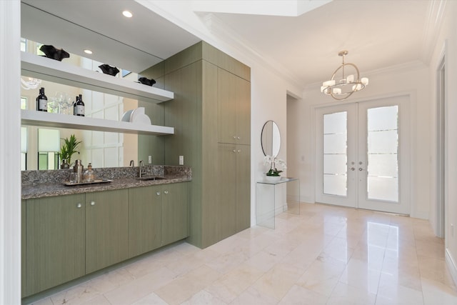 indoor wet bar with french doors, a chandelier, ornamental molding, and pendant lighting