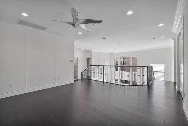 empty room featuring a ceiling fan, ornamental molding, dark wood-type flooring, recessed lighting, and baseboards