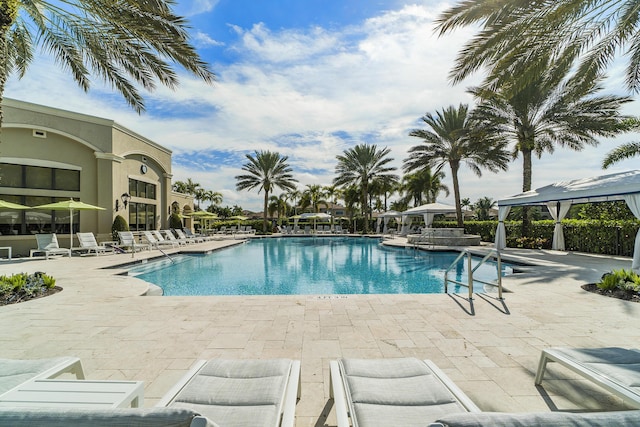 community pool with a gazebo and a patio