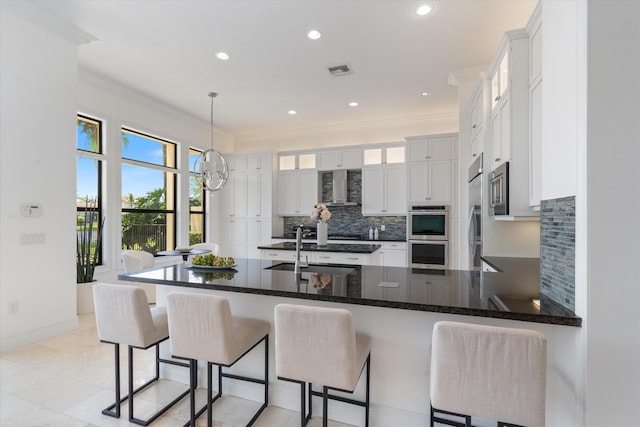 kitchen featuring a sink, stainless steel appliances, backsplash, a peninsula, and glass insert cabinets