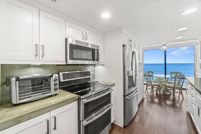 250 S Ocean Blvd Unit 2H, Boca Raton, FL 33432 - kitchen featuring appliances with stainless steel finishes, tasteful backsplash, white cabinetry, dark wood-style flooring, and recessed lighting