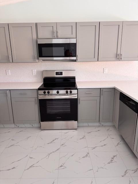 21 Walcott Dr, Boynton Beach, FL 33426 - kitchen featuring stainless steel appliances, gray cabinets, light marble finish flooring, and light countertops