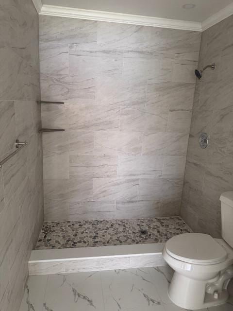 21 Walcott Dr, Boynton Beach, FL 33426 - bathroom featuring toilet, ornamental molding, tiled shower, and marble look tile flooring