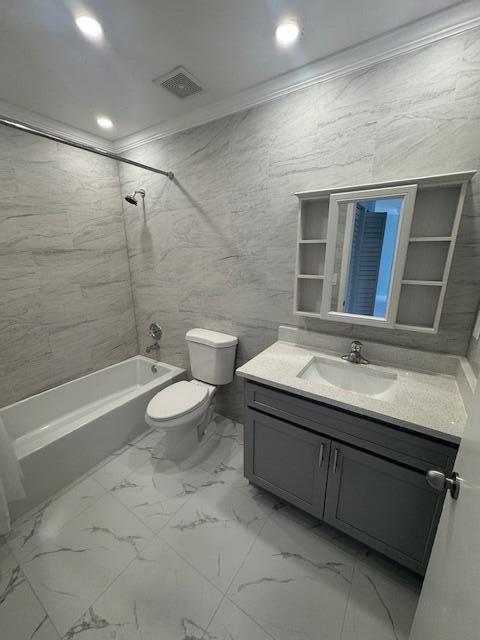 21 Walcott Dr, Boynton Beach, FL 33426 - bathroom featuring crown molding, toilet, vanity, marble look tile flooring, and bathing tub / shower combination