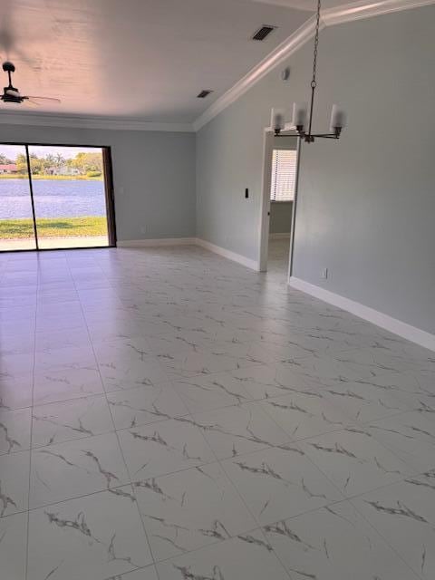 21 Walcott Dr, Boynton Beach, FL 33426 - empty room featuring ornamental molding, baseboards, a chandelier, marble finish flooring, and a water view