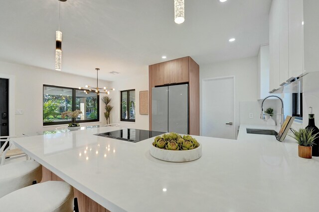 2924 NW 6th Ave, Wilton Manors, FL 33311 - kitchen featuring freestanding refrigerator, a peninsula, a sink, light countertops, and brown cabinets