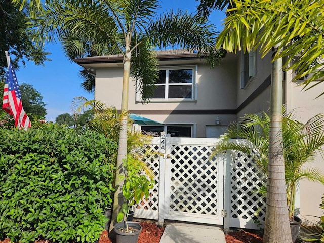 24 Bedford Ct Unit A, Royal Palm Beach, FL 33411 - view of front of property with a gate and stucco siding