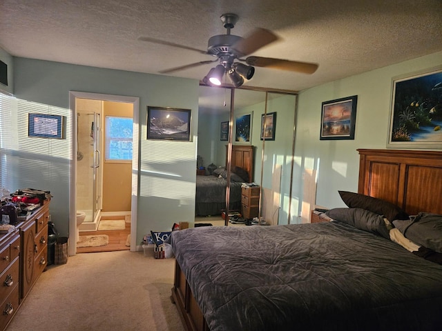 24 Bedford Ct Unit A, Royal Palm Beach, FL 33411 - bedroom featuring light carpet, a textured ceiling, a ceiling fan, connected bathroom, and a closet