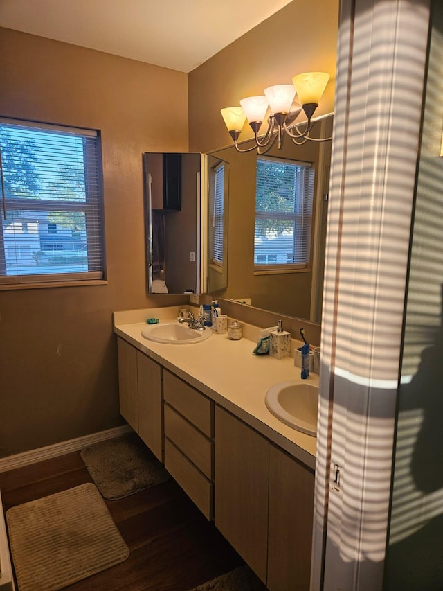 24 Bedford Ct Unit A, Royal Palm Beach, FL 33411 - bathroom with double vanity, wood finished floors, a chandelier, and baseboards