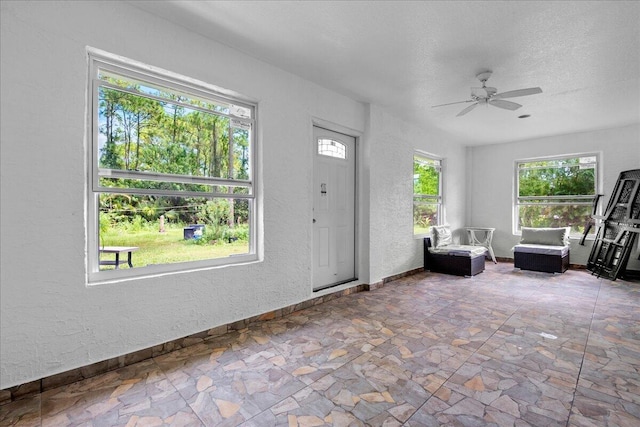 16931 N 78th Rd N, The Acreage, FL 33470 - foyer entrance featuring a textured wall, stone finish floors, baseboards, ceiling fan, and a textured ceiling