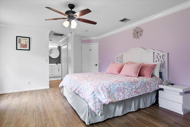 16931 N 78th Rd N, The Acreage, FL 33470 - bedroom with wood finished floors, ornamental molding, baseboards, a ceiling fan, and connected bathroom