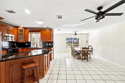 10056 Country Brook Rd, Boca Raton, FL 33428 - kitchen with stainless steel microwave, light tile patterned flooring, a ceiling fan, and recessed lighting