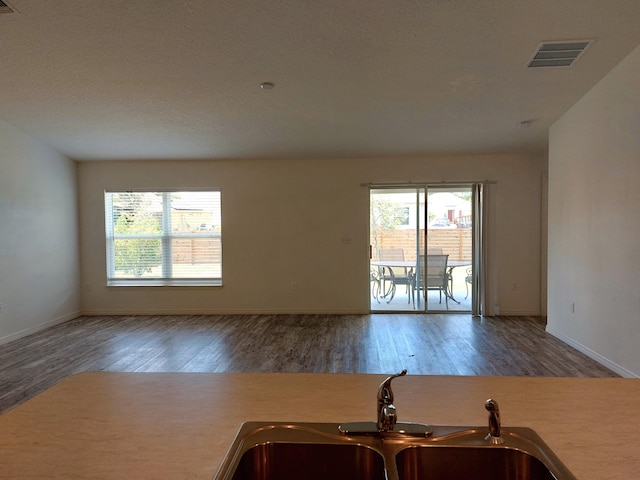 1614 SW Sylvester Ln, Port Saint Lucie, FL 34984 - kitchen with a sink, wood finished floors, baseboards, and light countertops