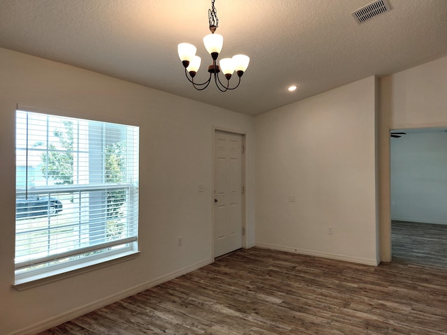 1614 SW Sylvester Ln, Port Saint Lucie, FL 34984 - empty room with a chandelier, wood finished floors, a textured ceiling, baseboards, and recessed lighting