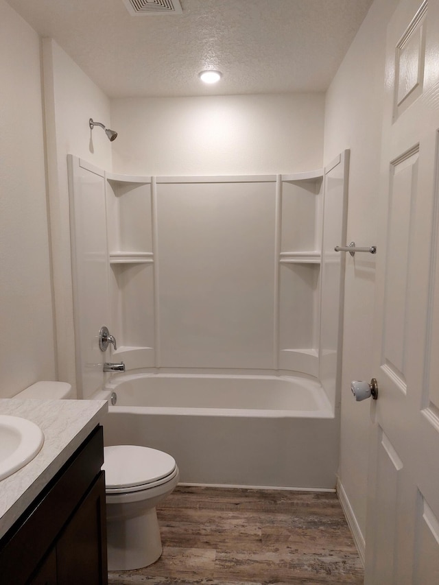 1614 SW Sylvester Ln, Port Saint Lucie, FL 34984 - bathroom featuring wood finished floors, toilet, vanity, shower / washtub combination, and a textured ceiling