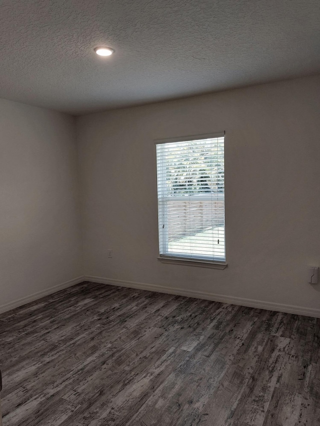 1614 SW Sylvester Ln, Port Saint Lucie, FL 34984 - spare room with dark wood-type flooring, a textured ceiling, and baseboards