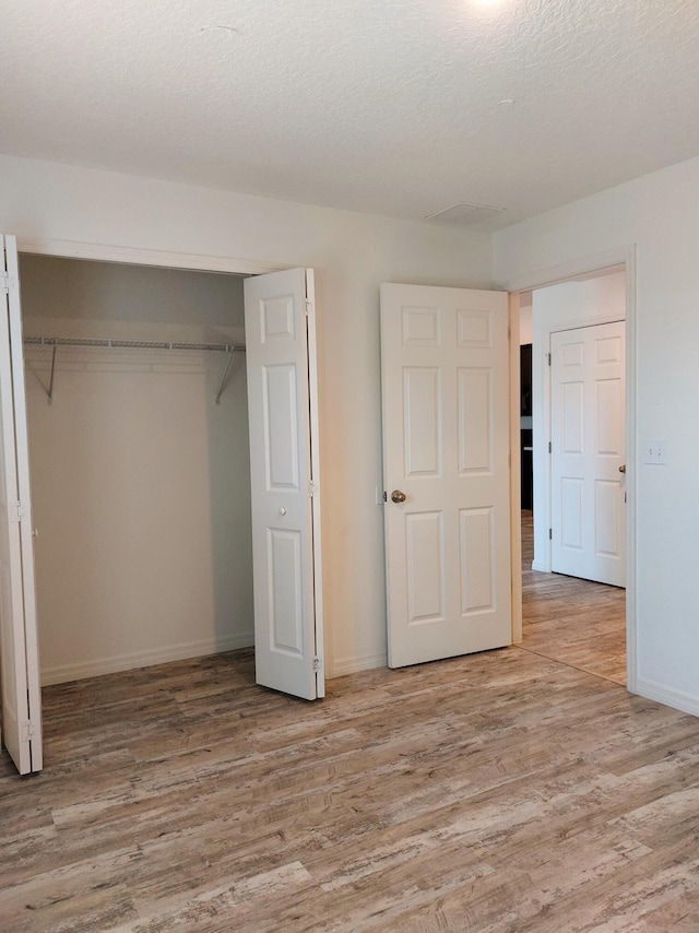 1614 SW Sylvester Ln, Port Saint Lucie, FL 34984 - unfurnished bedroom with wood finished floors, a closet, and baseboards