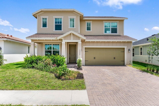 19659 Rugged Trunk Trl, Loxahatchee, FL 33470 - view of front facade featuring an attached garage, roof with shingles, decorative driveway, board and batten siding, and a front yard