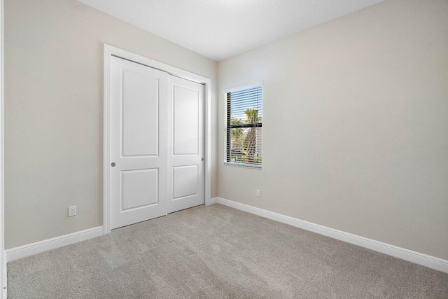 4817 Saint Armands Way, Westlake, FL 33470 - unfurnished bedroom with light colored carpet, baseboards, and a closet