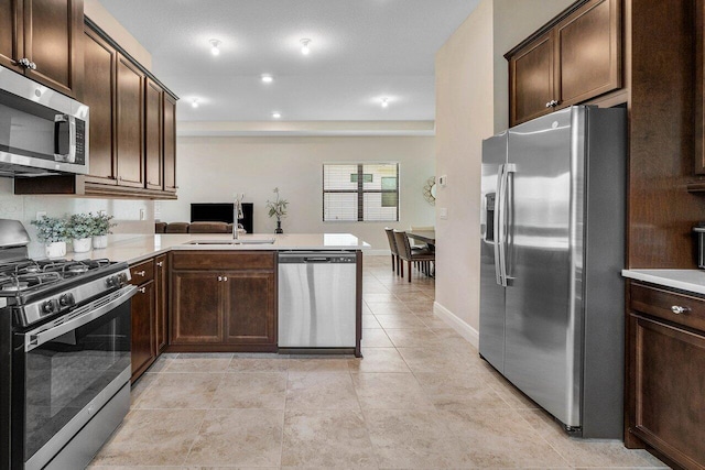 4817 Saint Armands Way, Westlake, FL 33470 - kitchen with appliances with stainless steel finishes, a sink, dark brown cabinets, light countertops, and recessed lighting