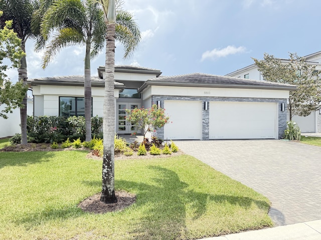 8803 Skyward St, Boca Raton, FL 33496 - view of front of home with an attached garage, decorative driveway, a front lawn, and stucco siding