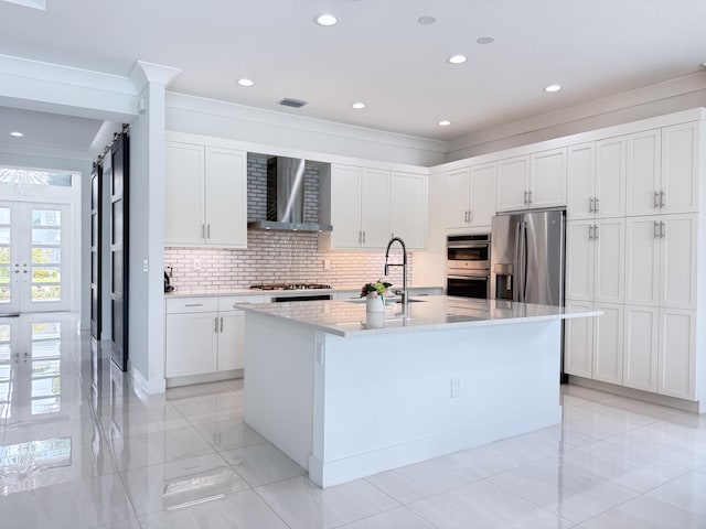 8803 Skyward St, Boca Raton, FL 33496 - kitchen featuring wall chimney range hood, a sink, stainless steel appliances, decorative backsplash, and a center island with sink