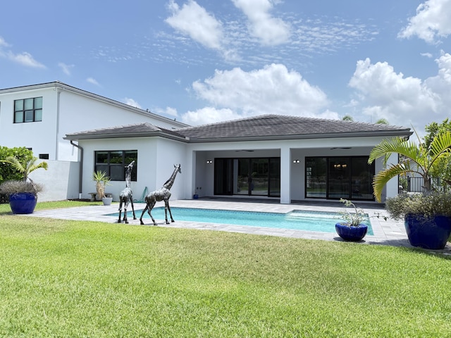 8803 Skyward St, Boca Raton, FL 33496 - back of house featuring stucco siding, a lawn, an outdoor pool, and a patio area