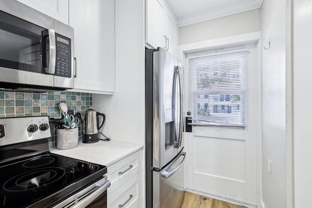 200 E Royal Palm Rd Unit 3040, Boca Raton, FL 33432 - kitchen with appliances with stainless steel finishes, tasteful backsplash, white cabinets, ornamental molding, and light wood-type flooring