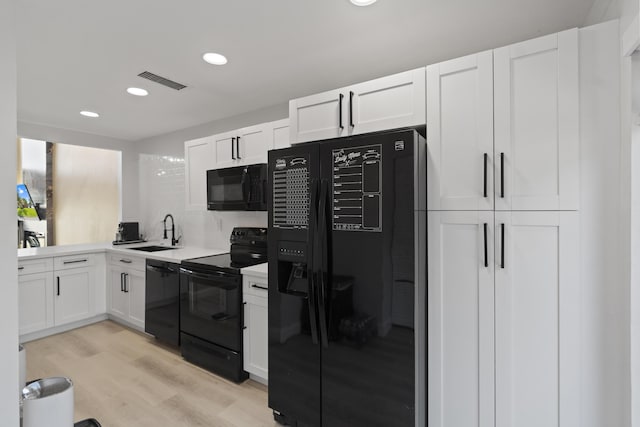 10650 NW 30th Pl Unit 1, Sunrise, FL 33322 - kitchen featuring black appliances, a sink, light wood-style floors, light countertops, and white cabinets