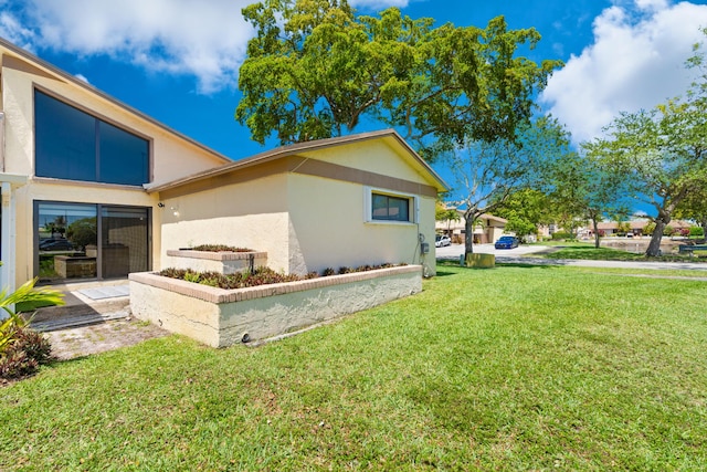 10650 NW 30th Pl Unit 1, Sunrise, FL 33322 - view of side of home featuring a yard and stucco siding