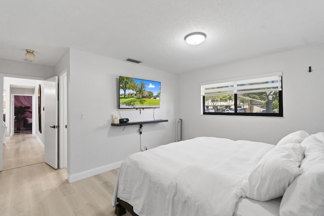 10650 NW 30th Pl Unit 1, Sunrise, FL 33322 - bedroom featuring light wood-style floors, a textured ceiling, and baseboards