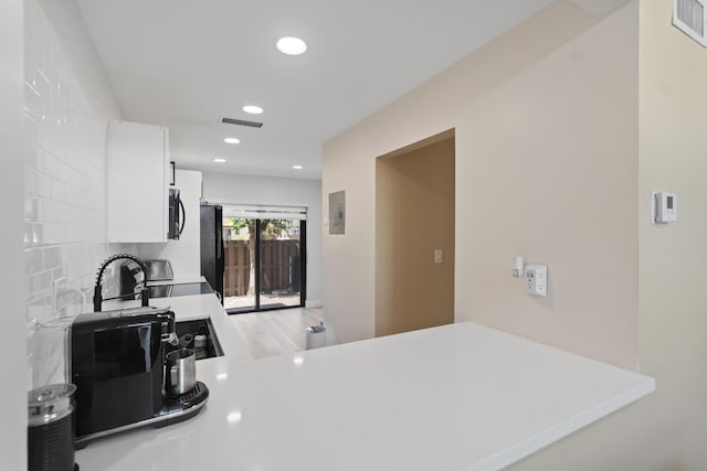 10650 NW 30th Pl Unit 1, Sunrise, FL 33322 - kitchen with recessed lighting, white cabinets, a peninsula, light countertops, and backsplash