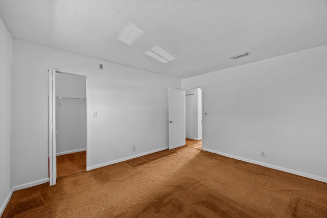 300 NW 30th Ct Unit 202, Pompano Beach, FL 33064 - unfurnished bedroom with carpet floors, baseboards, a textured ceiling, and a walk in closet