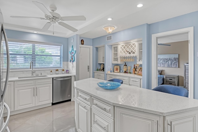 2018 S Federal Hwy Unit 304, Boynton Beach, FL 33435 - kitchen with stainless steel dishwasher, a sink, a kitchen island, white cabinets, and a ceiling fan