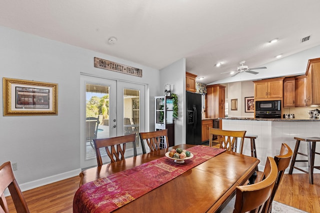 15180 69th Dr N, Palm Beach Gardens, FL 33418 - dining area featuring french doors, light wood-style floors, baseboards, ceiling fan, and vaulted ceiling