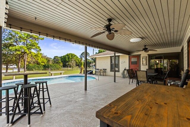 15180 69th Dr N, Palm Beach Gardens, FL 33418 - outdoor pool featuring outdoor dining area, ceiling fan, a patio, and a lawn