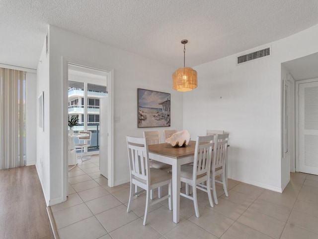 3554 Ocean Dr Unit 202, Vero Beach, FL 32963 - dining room with a textured ceiling, baseboards, and light tile patterned floors