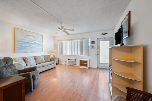 185 Andover H W, West Palm Beach, FL 33417 - living area featuring ceiling fan, light wood finished floors, a textured ceiling, a wall mounted AC, and baseboards