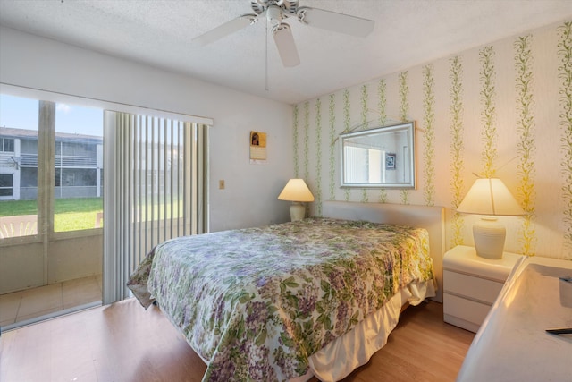 185 Andover H W, West Palm Beach, FL 33417 - bedroom with access to exterior, wood finished floors, a ceiling fan, and wallpapered walls