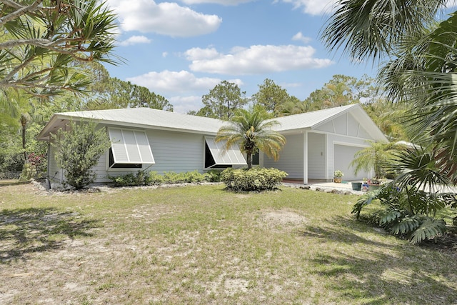 11195 N 159th Ct N, Jupiter, FL 33478 - ranch-style house featuring a front lawn, an attached garage, board and batten siding, and metal roof