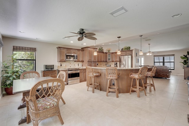 11195 N 159th Ct N, Jupiter, FL 33478 - kitchen with appliances with stainless steel finishes, ceiling fan, tasteful backsplash, brown cabinetry, and recessed lighting
