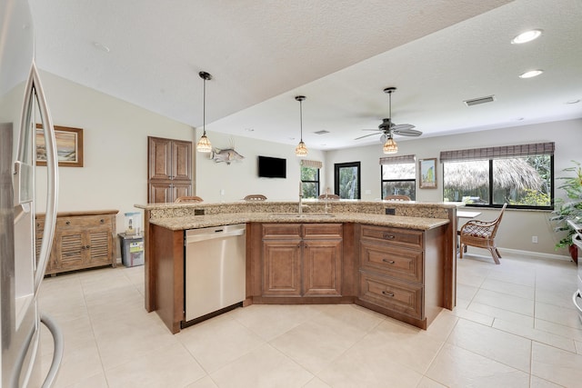 11195 N 159th Ct N, Jupiter, FL 33478 - kitchen featuring appliances with stainless steel finishes, a sink, healthy amount of natural light, brown cabinets, and recessed lighting