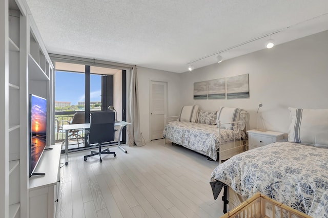 2697 N Ocean Blvd Unit 407-F, Boca Raton, FL 33431 - bedroom with track lighting, floor to ceiling windows, a desk, wood finished floors, and access to outside