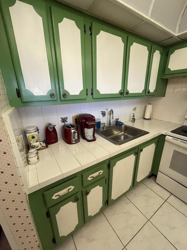 262 Sussex M, West Palm Beach, FL 33417 - kitchen featuring a sink, electric range, green cabinets, and decorative backsplash