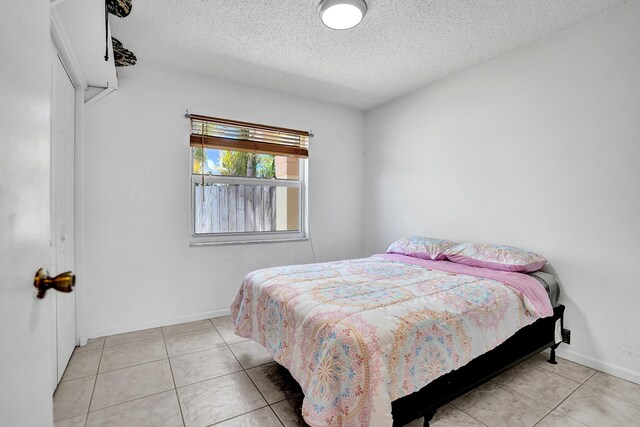 8066 Stirrup Cay Ct, Boynton Beach, FL 33436 - bedroom with a textured ceiling, tile patterned floors, and baseboards